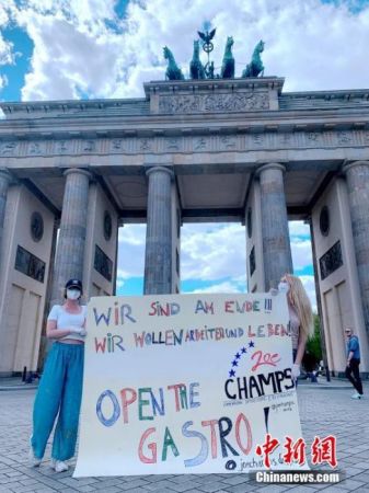 　　当地时间4月26日，餐饮业者在德国柏林勃兰登堡门前打出“开放餐馆”的标语抗议。中新社记者 彭大伟 摄