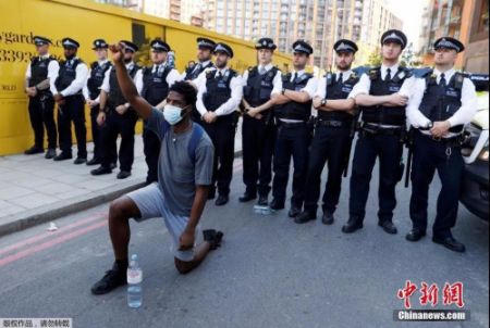 　　5月31日，英国伦敦的美国大使馆附近，一名抗议者在示威活动中单膝跪地。
