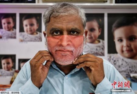 　　资料图：印度为民众定制符合个人脸部特征的口罩，一名顾客拿到了自己的口罩进行试戴。