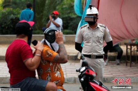 　　当地时间5月11日，印度新德里街头，为防止新冠肺炎疫情扩散，警察带着一款特制头盔上岗，只需看一眼就知道行人体温是否正常。