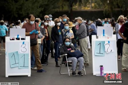 　　图片资料图：当地时间2021年1月13日，美国加利福尼亚州橙县政府在当地迪士尼乐园度假区内安置了大型临时新冠疫苗接种点。图为人们在加州迪士尼乐园度假区接种疫苗的地点排长队等候。