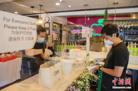 资料图：美国硅谷腹地库比蒂诺商圈的“青苹果”餐厅在一条长桌上立起透明的挡板，店员与取餐者隔着挡板交流。中新社记者 刘关关 摄