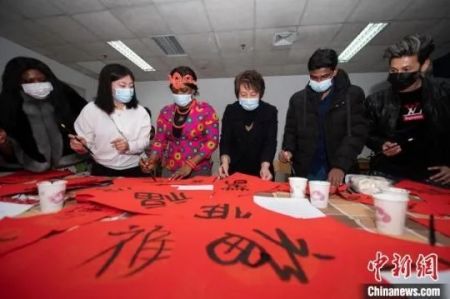 　资料图：学校老师指导留学生在红纸上写对联。韦亮 摄