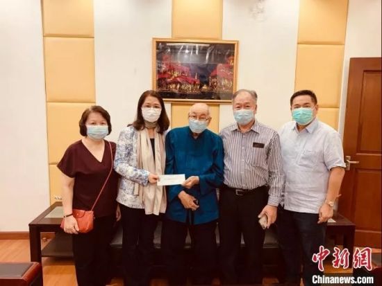 2月6日，93岁的菲华庄垂楷先生（右三）在长子、长媳与次子的陪同下来到了驻菲使馆领侨处，将300万比索（合41万人民币）的支票，交由大使馆董洪亚领事（左二）转交武汉同胞。　驻菲使馆供图　