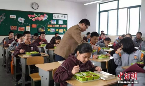 南京钟英中学的校长走进教室与学生一起吃中饭。葛勇