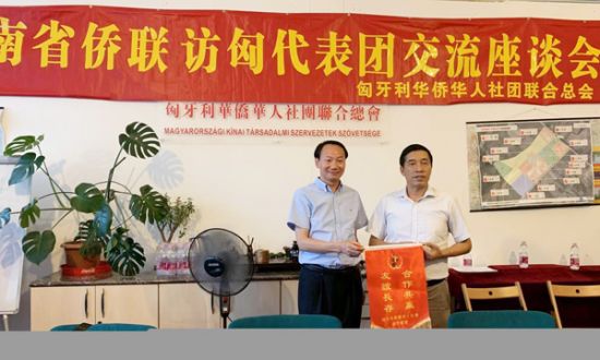 匈华总会主席余美明(右)向河南省侨联副主席刘合生(左)赠送本会锦旗。