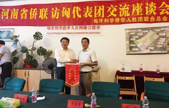 匈华总会主席余美明(右)向安阳市人民政府副市长李长治(左)赠送本会锦旗。