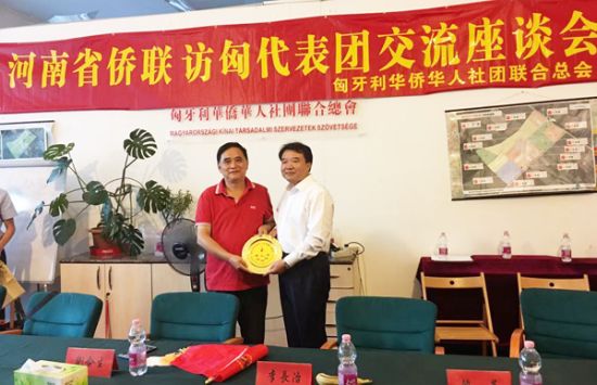 匈华总会执行主席刘文建(左)向安阳市人民政府副市长李长治(右)赠送本会会徽盘。