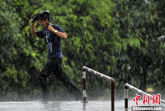 5月14日,广西南宁,一名男子在雨中奔跑.中新社发