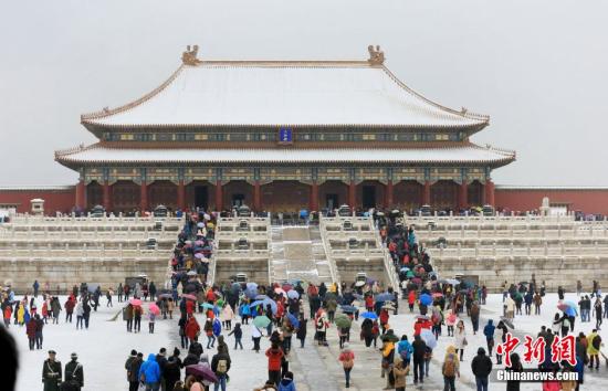 2015年11月22日，农历小雪节气，北京迎来强降雪，游人不畏大雪，故宫排队购票，一赏紫禁城雪景。（图片来源：视觉中国）