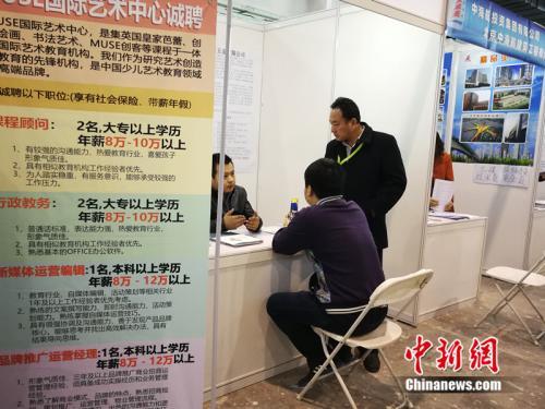 　　2018年北京春季综合人才招聘会现场，一名男子在某企业展台前咨询。中新网