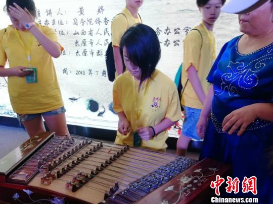 海外华裔青少年在太原市群众艺术馆学习中国传统乐器。